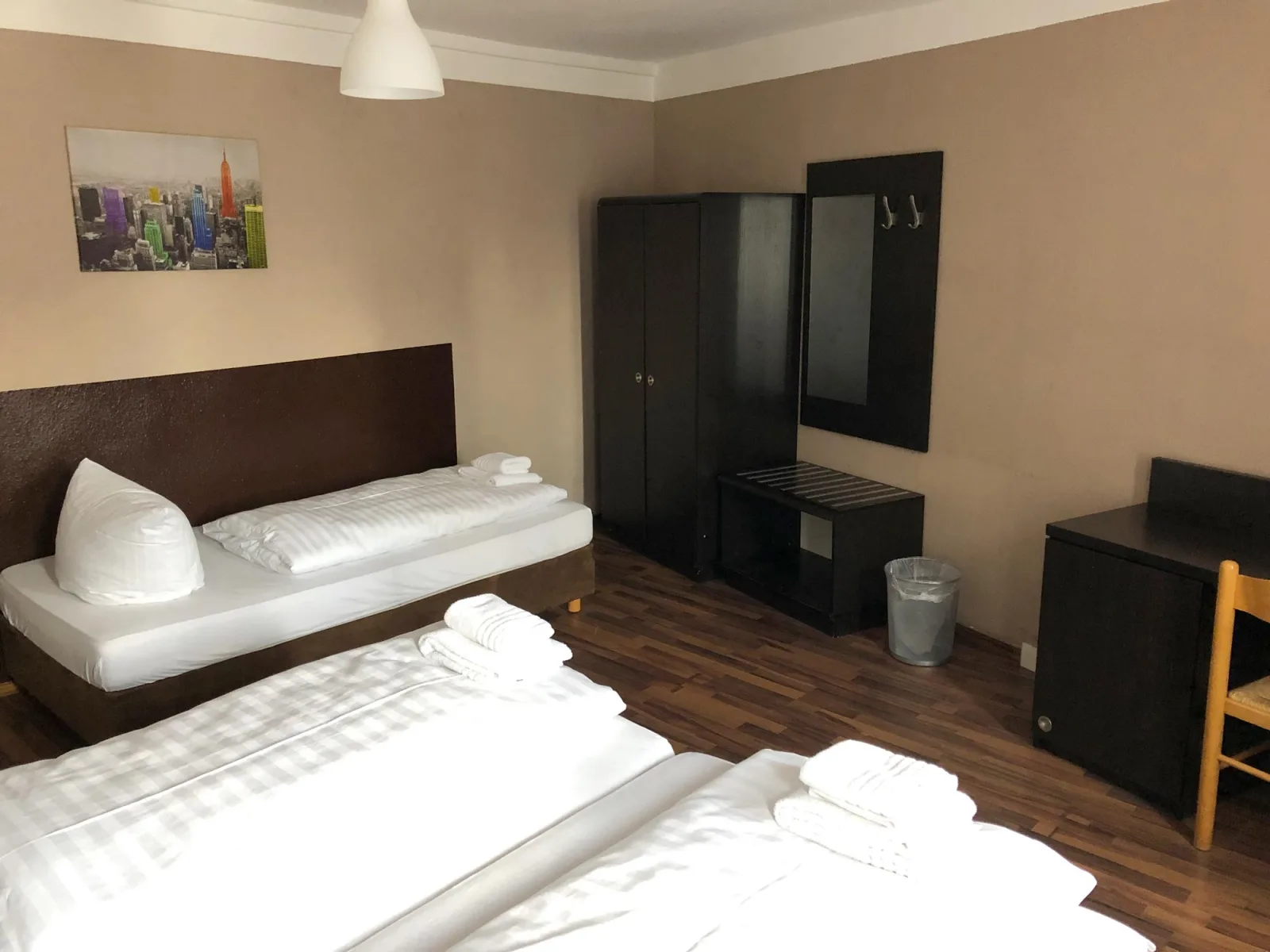 Dreibettzimmer im Hotel-Pension Reiter Berlin mit drei Betten und Kleiderschrank